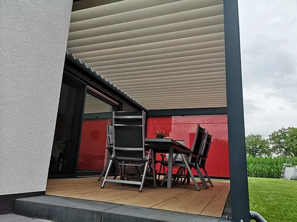 Überdachte Terrasse mit Lamellendach, Gartenmöbeln und modernem Sonnenschutzsystem.