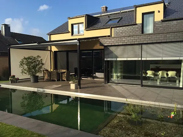 Modernes Einfamilienhaus mit großer Terrasse, Pool und stilvoller Glasüberdachung im Garten.